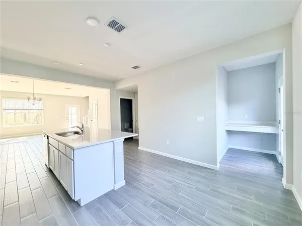 a open kitchen with a sink and wooden floor