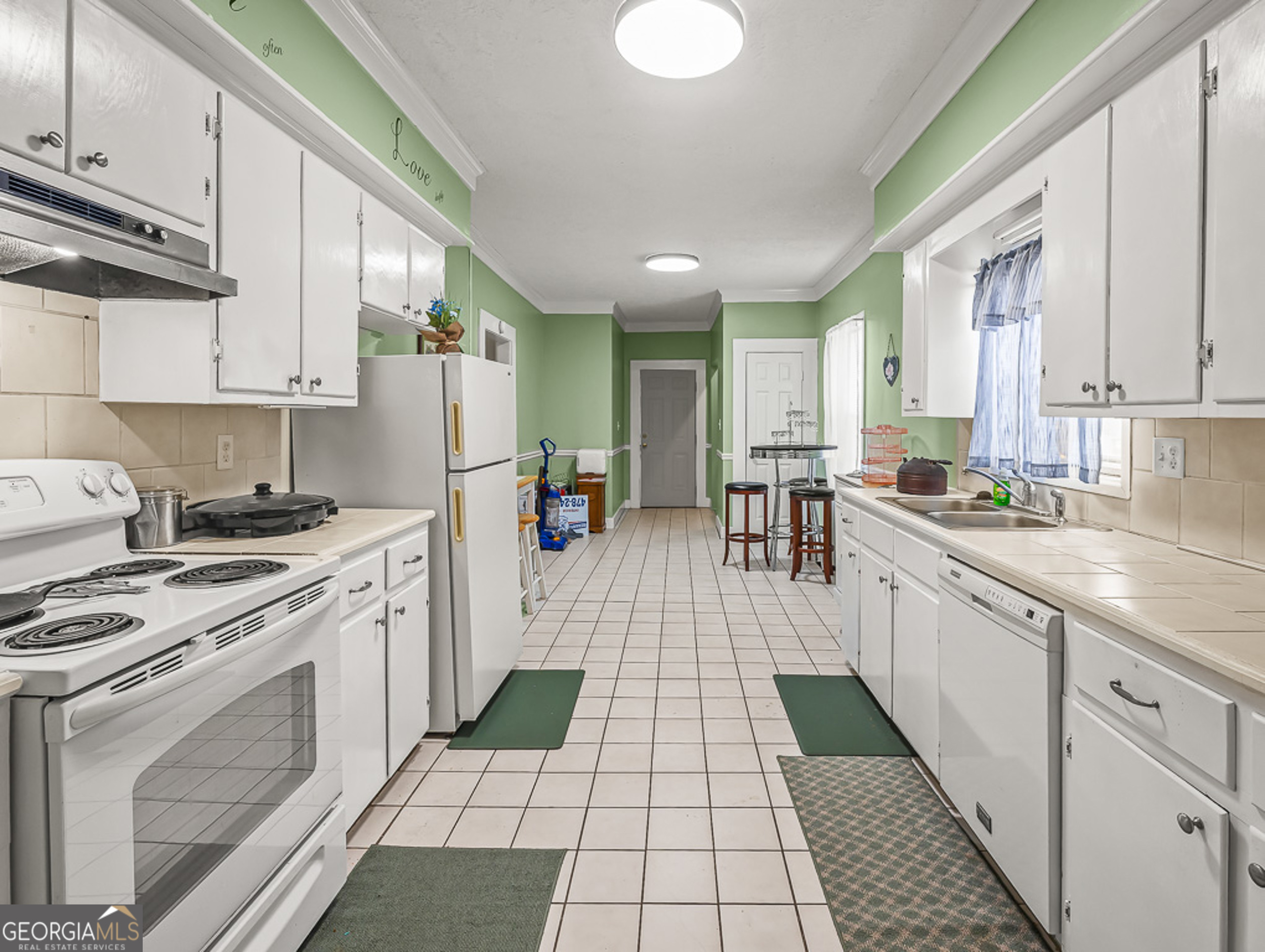 517 North Masonic Street Millen, GA 30442 - Photo 14 of 40 a kitchen with a sink a stove and cabinets