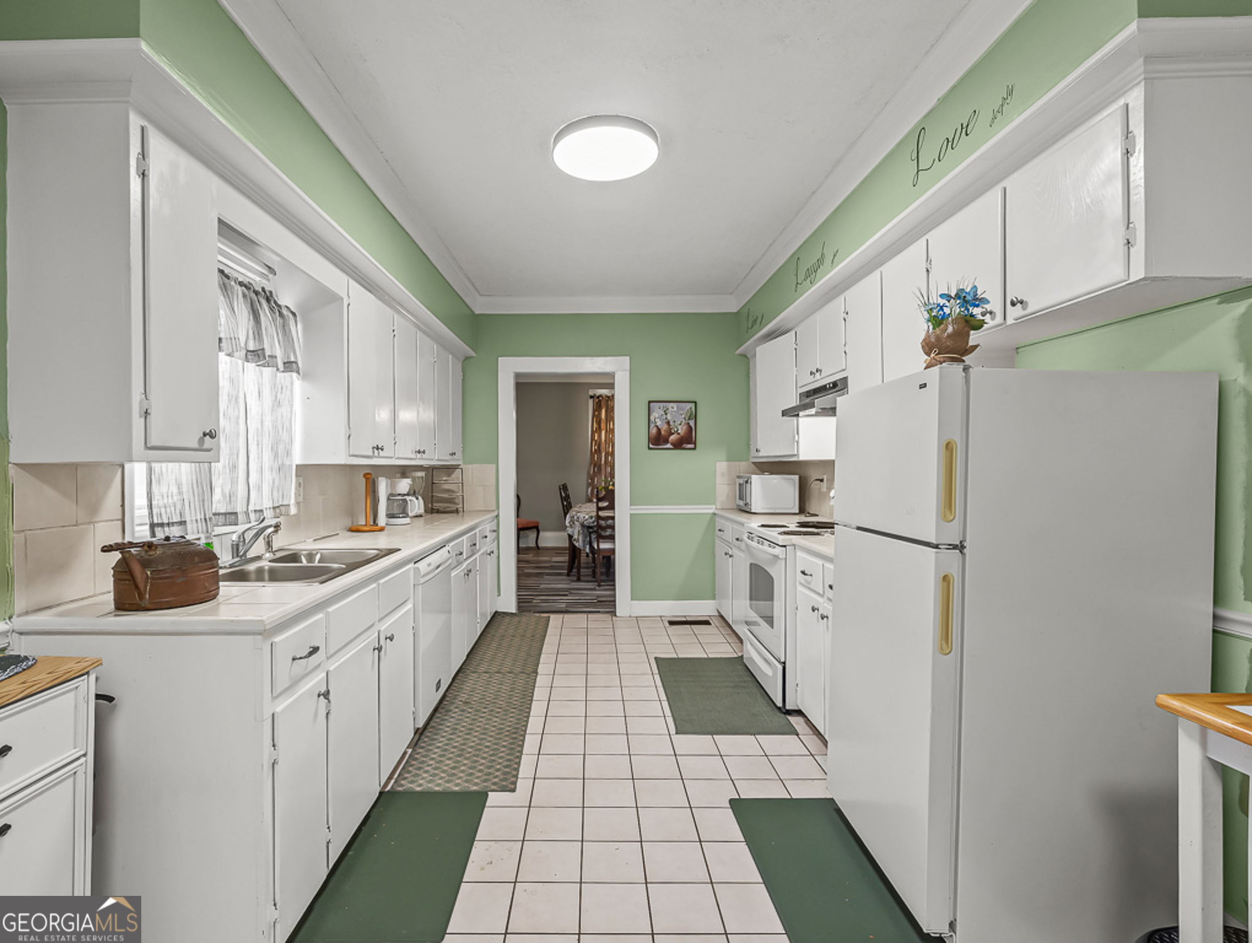 517 North Masonic Street Millen, GA 30442 - Photo 16 of 40 a kitchen with white cabinets and white appliances