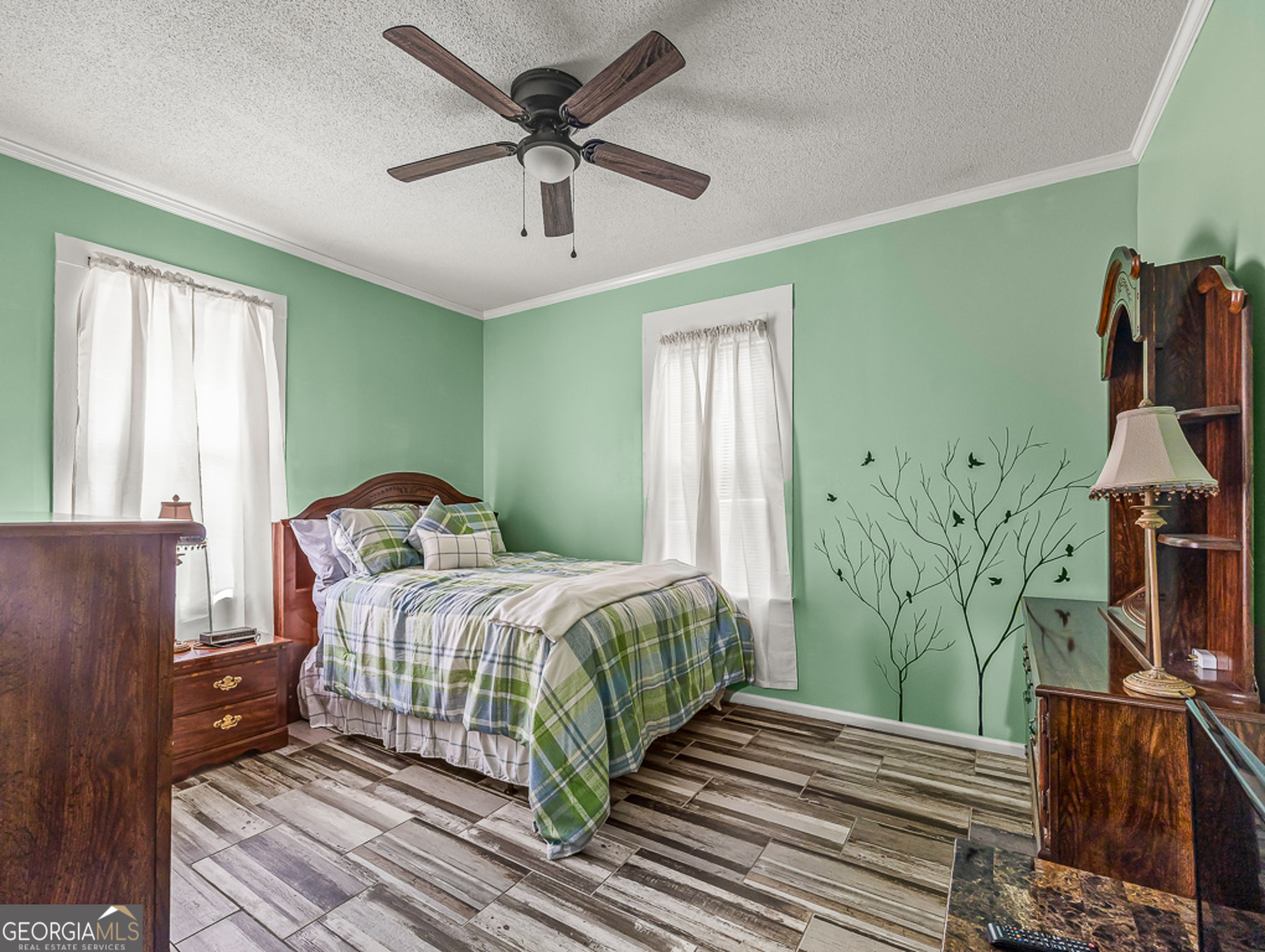 517 North Masonic Street Millen, GA 30442 - Photo 25 of 40 a bedroom with a bed and a chandelier