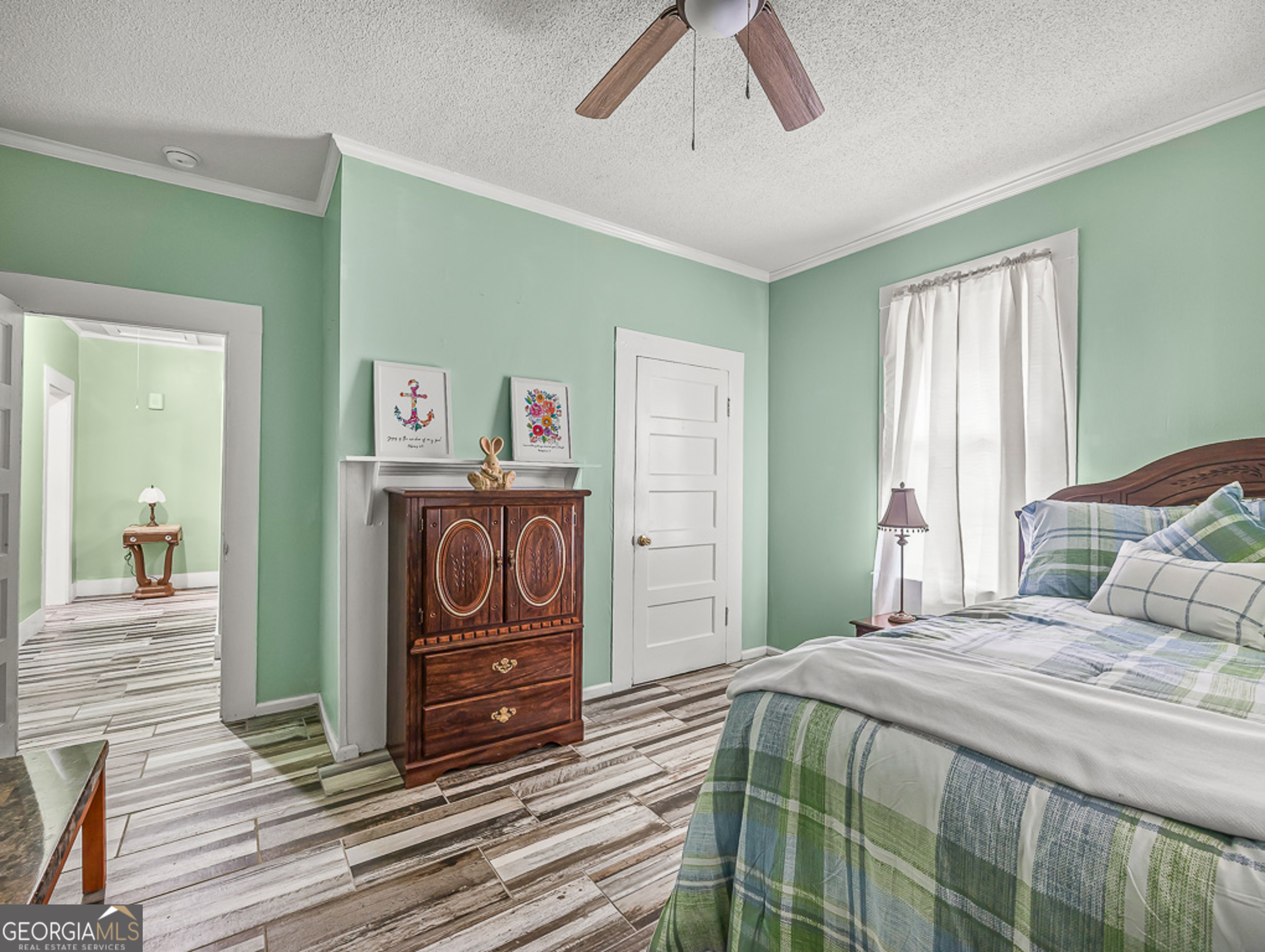 517 North Masonic Street Millen, GA 30442 - Photo 30 of 40 a bedroom with a bed and a chandelier