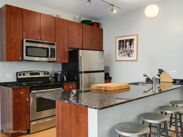 a kitchen with granite countertop a sink stove and refrigerator