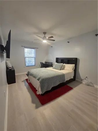 a spacious bedroom with a bed and a flat screen tv