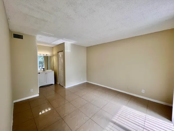 a view of a hallway with wooden floor and a bathroom
