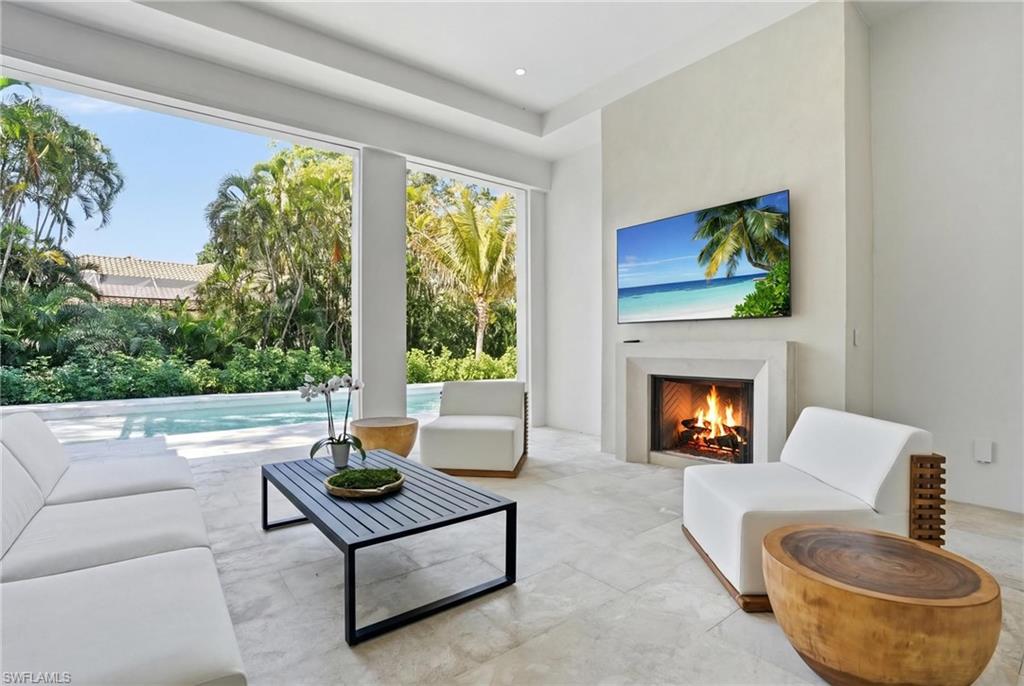4851 Crayton Road Naples, FL 34103 - Photo 26 of 33 a living room with furniture and a fireplace