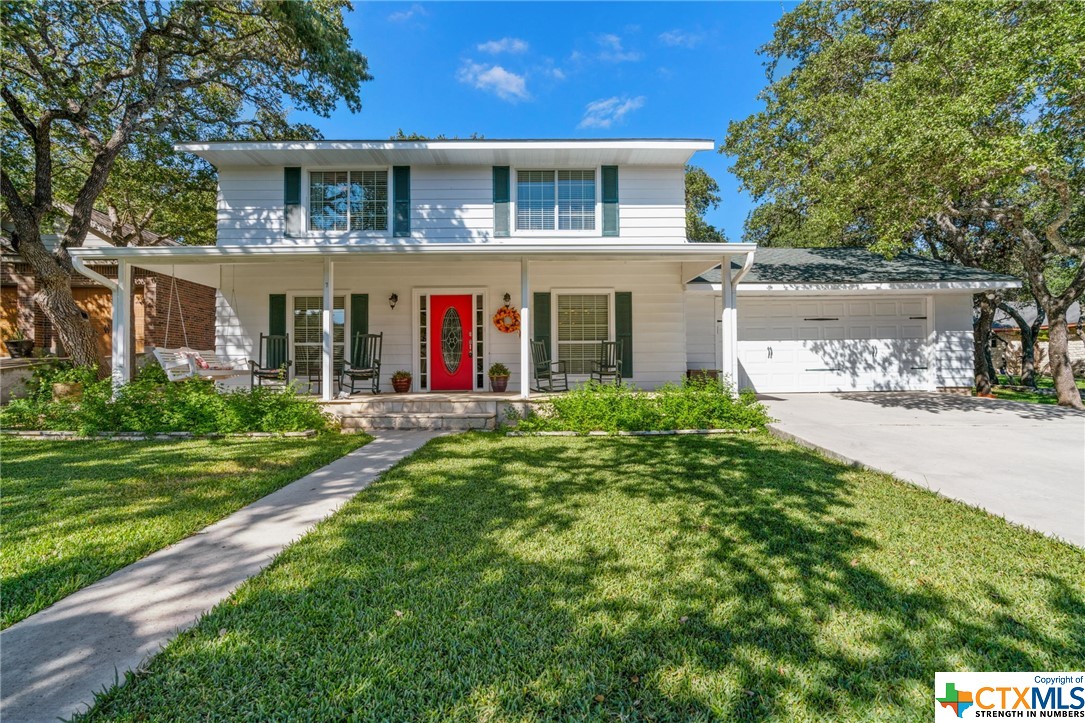 7 Pebblebrook Lane Wimberley, TX 78676 - Photo 1 of 1 a front view of a house with a yard and garage