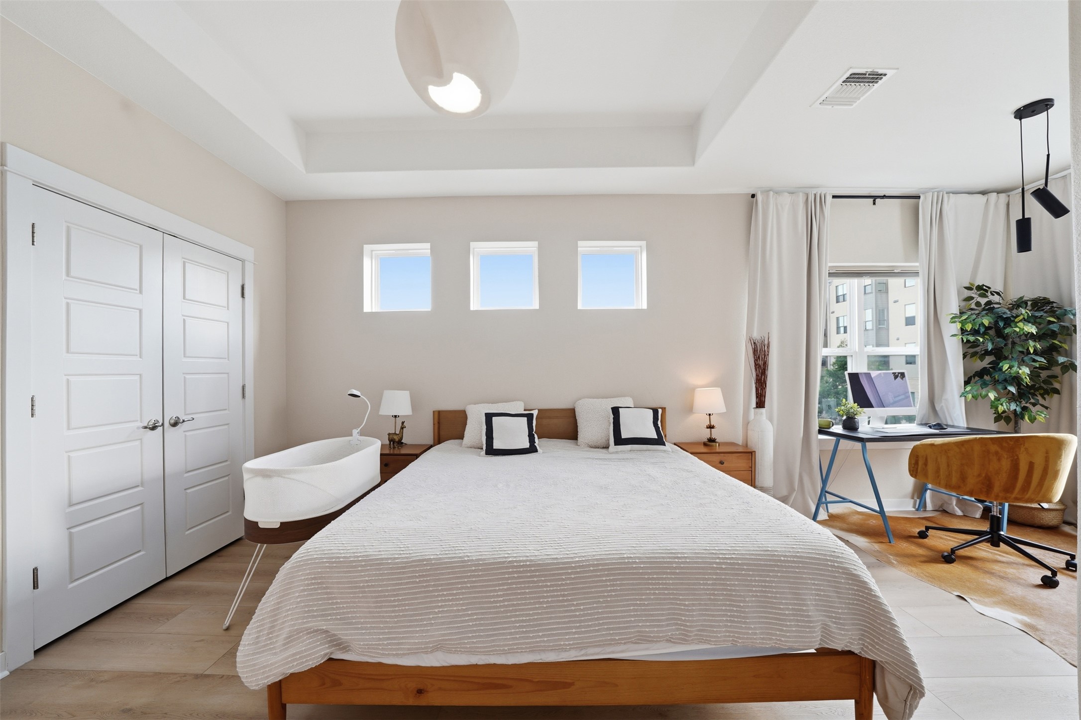 3901 Vaughan Street Austin, TX 78723 - Photo 20 of 37 Recessed ceiling with an integrated light fixture, three high horizontal windows, light wood-finish flooring, and white panel doors