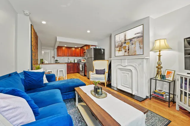 a kitchen with stainless steel appliances granite countertop a refrigerator a sink dishwasher a stove with wooden cabinets and floor