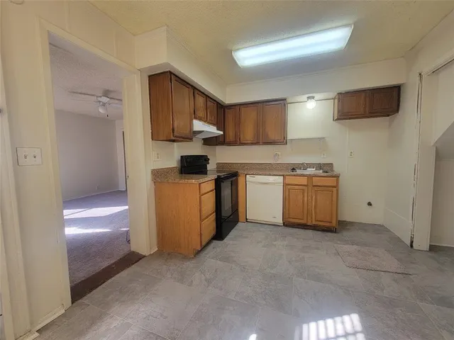 a kitchen with stainless steel appliances granite countertop a refrigerator sink and stove