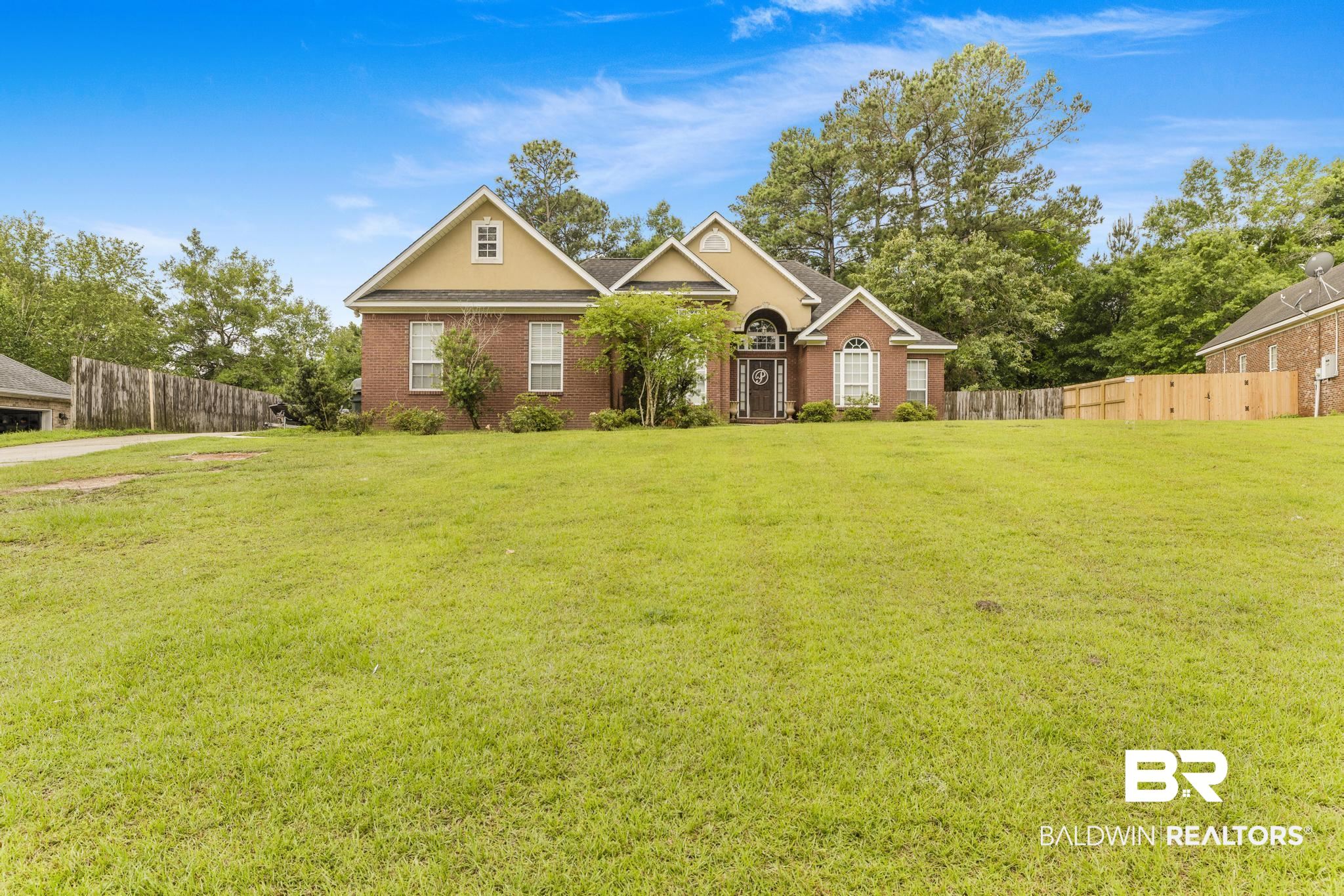 35814 Delvan Lane Bay Minette, AL 36507 - Photo 45 of 53 Brick exterior with a prominent arched entry, gabled rooflines, and a large front lawn