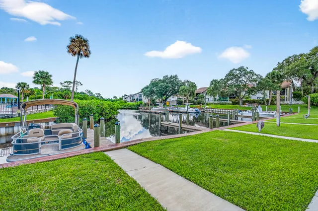 a front view of a house with a yard and potted plants