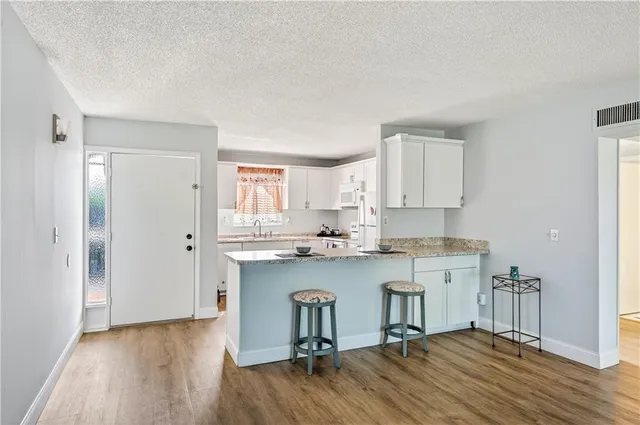 a kitchen with a sink cabinets and wooden floor