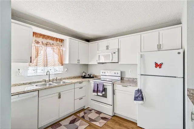 a kitchen with white cabinets and white appliances