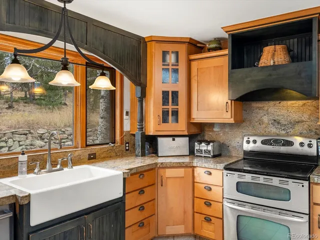 a kitchen with a sink a stove and cabinets