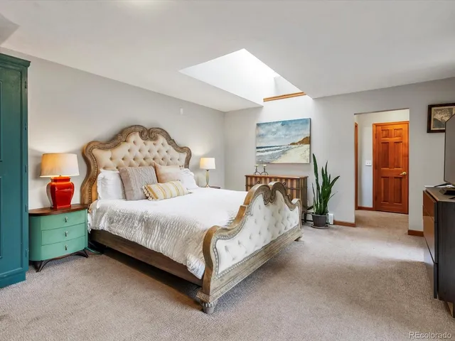 a bed sitting in a bedroom next to a lamp