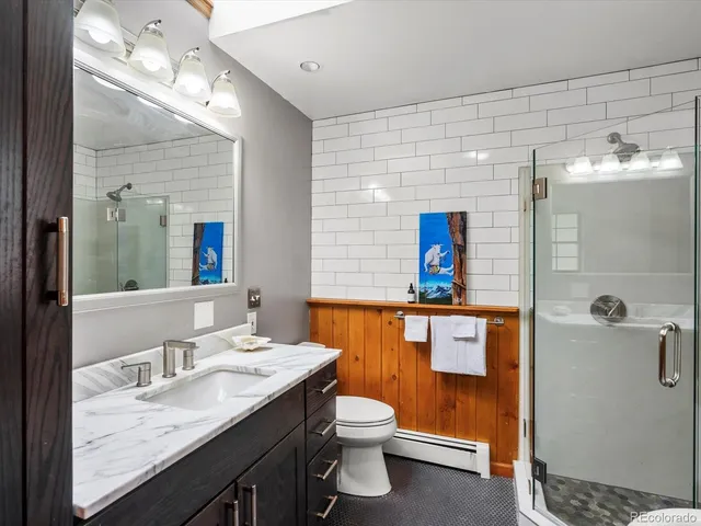 a bathroom with a sink a toilet and shower