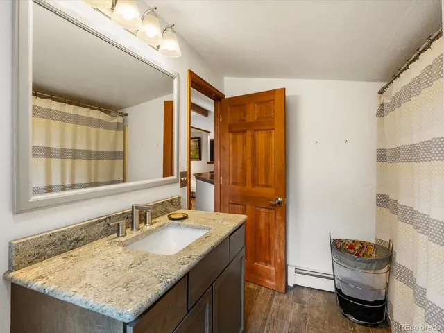 a bathroom with a granite countertop sink and a mirror