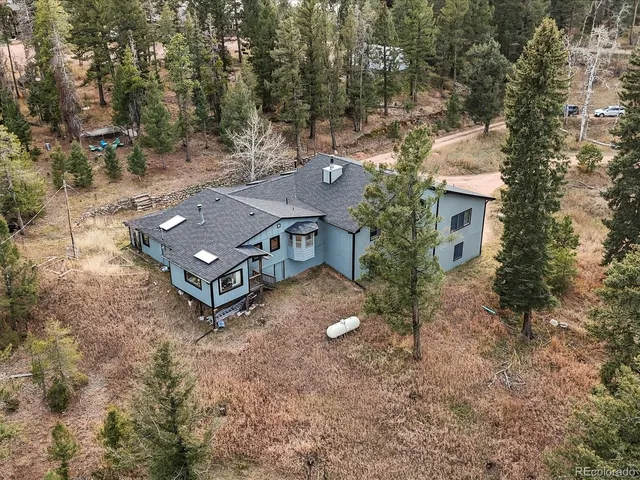 an aerial view of a house with yard and mountain view