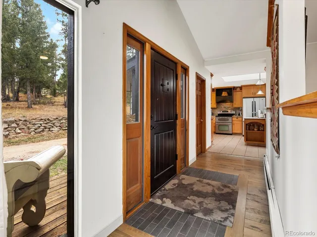 a view of a hallway with wooden floor and a living room