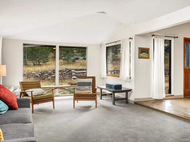 a living room with furniture and floor to ceiling windows