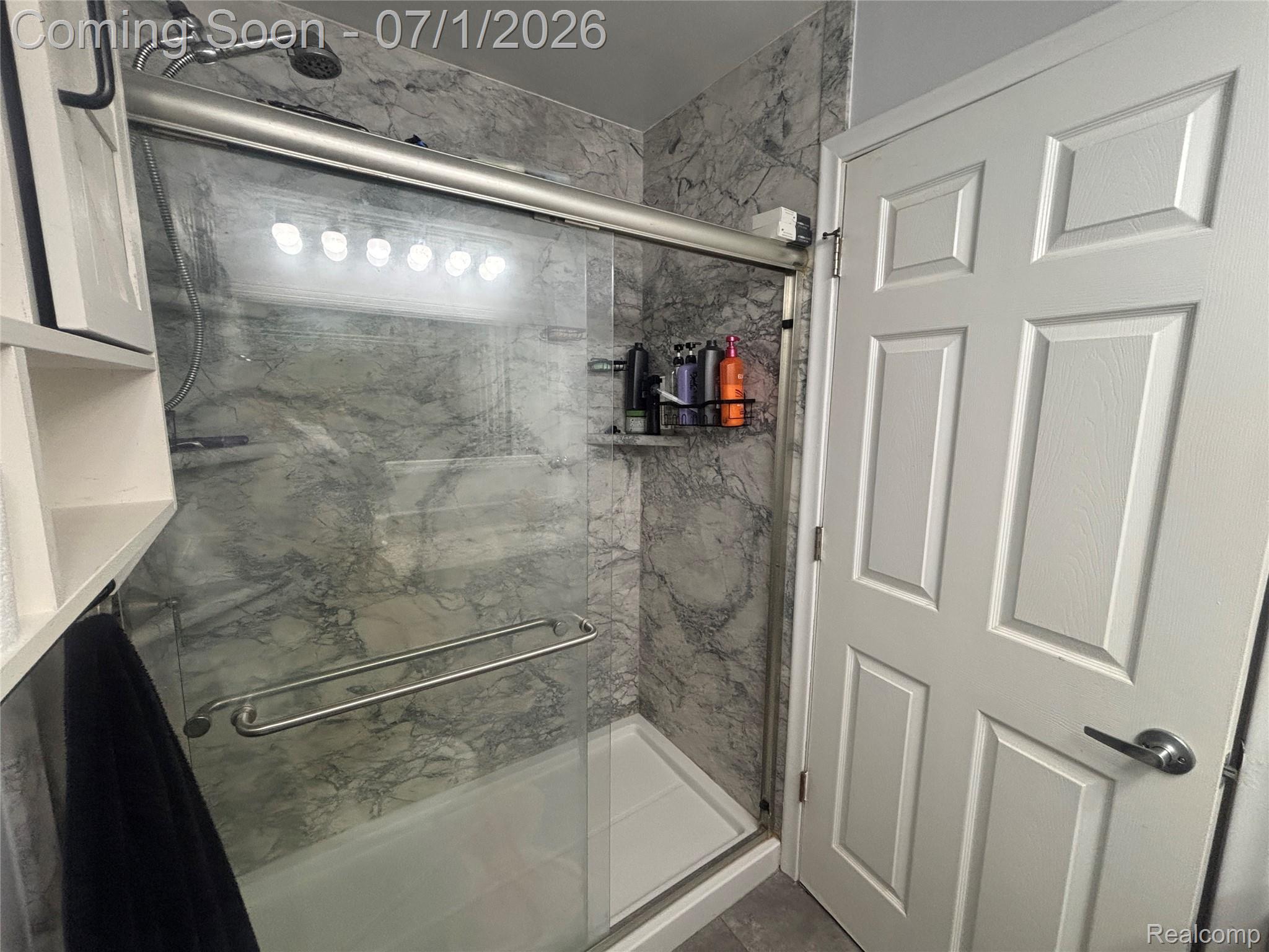 9844 Pine Knob Road Clarkston, MI 48348 - Photo 8 of 15 Shower enclosure with sliding glass doors, marble-finish tile surround, and a rain showerhead