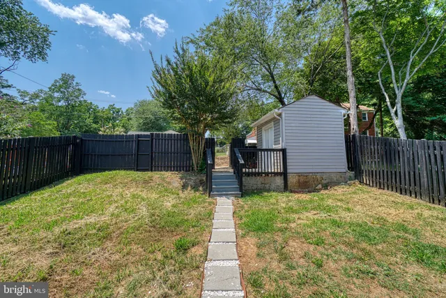 a view of a backyard with a small cabin and wooden fence
