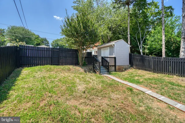 a view of a house with wooden deck and furniture