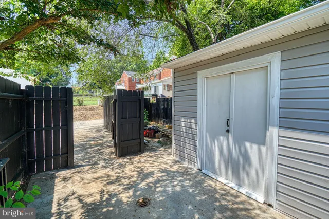 a backyard of a house with table and chairs and wooden fence