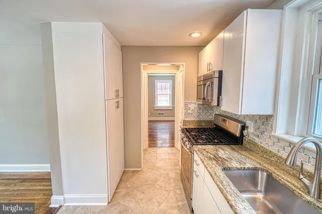 a kitchen with white cabinets and stainless steel appliances