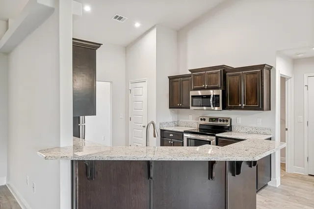 a kitchen with stainless steel appliances a stove refrigerator and microwave