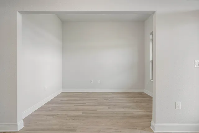 an empty room with windows and ceiling fan
