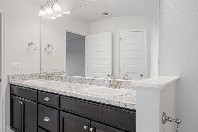 a bathroom with a double vanity sink and a mirror