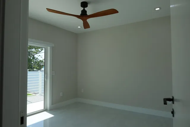 an empty room with a window and a fan