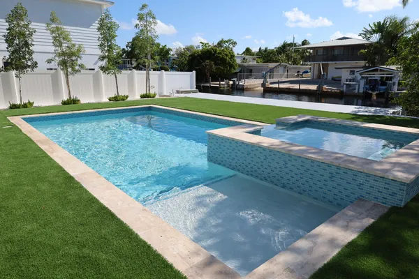 a view of a swimming pool with a patio and a yard