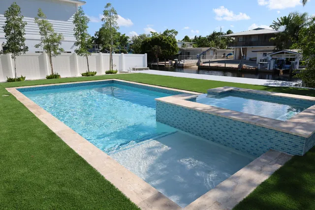 a view of a swimming pool with a patio and a yard