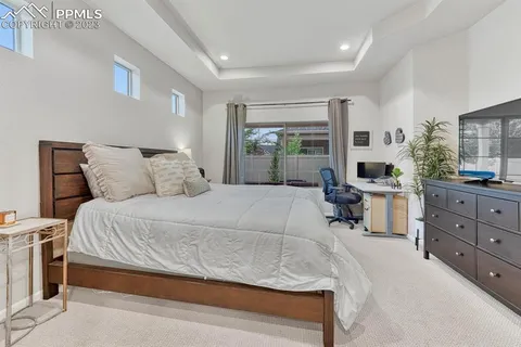 a bedroom with a large bed and windows