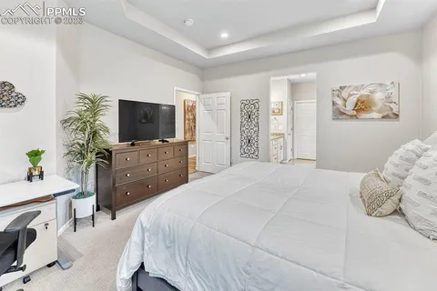 a spacious bedroom with a bed and a flat screen tv