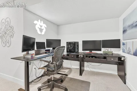 a view of a workspace with a flat screen tv and a window