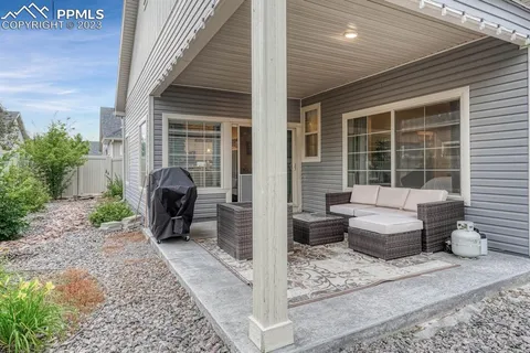 a view of a patio with couple of chairs and a potted plant