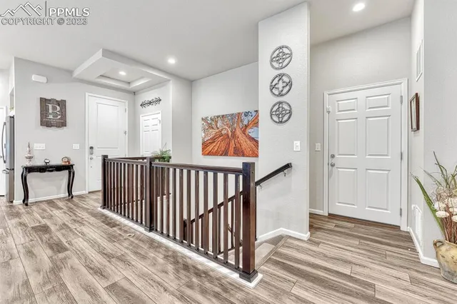a view of a hallway with wooden floor and stairs