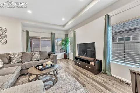 a living room with furniture a flat screen tv and a fireplace