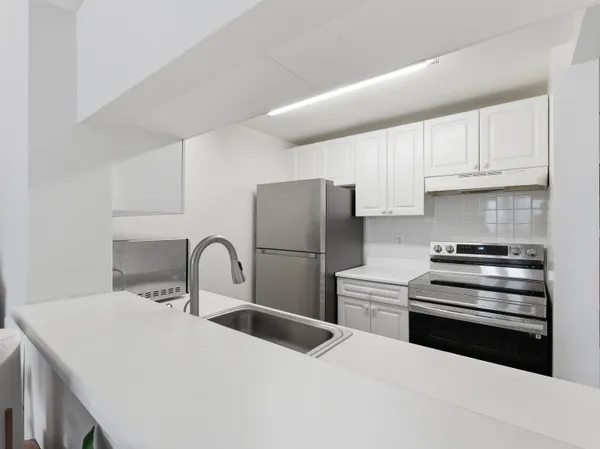 a kitchen with stainless steel appliances a sink a stove and refrigerator
