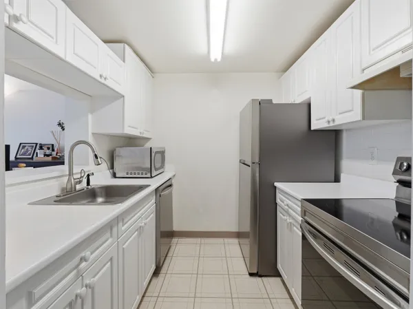 a kitchen with stainless steel appliances granite countertop a sink and a refrigerator