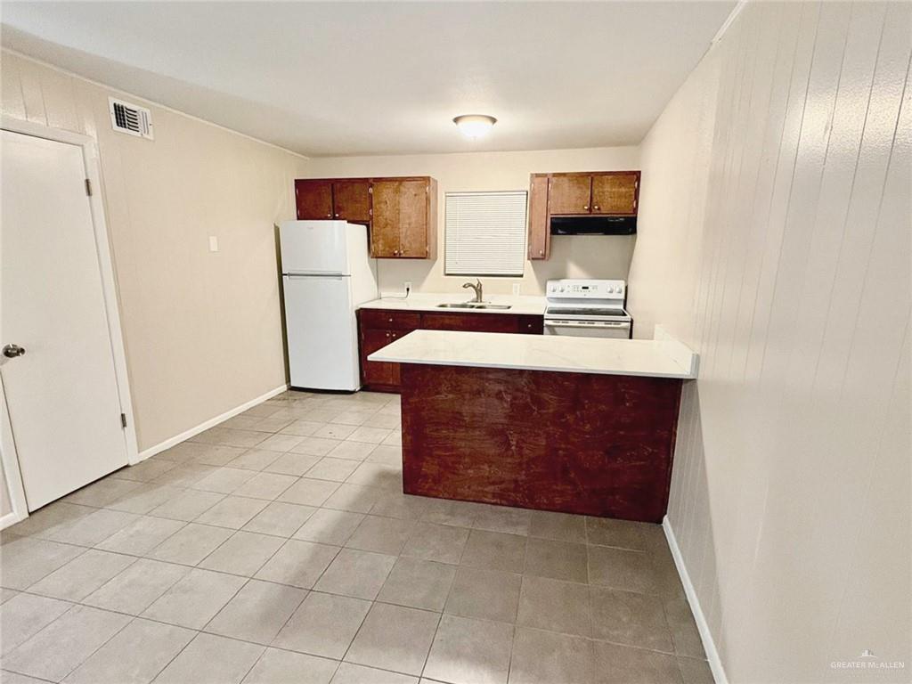 3616 Harvey Drive West, Unit 8 McAllen, TX 78501 - Photo 3 of 11 a large kitchen with a wooden floor and a refrigerator