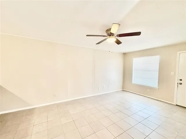 a view of a room with exposed radiator and ceiling fan