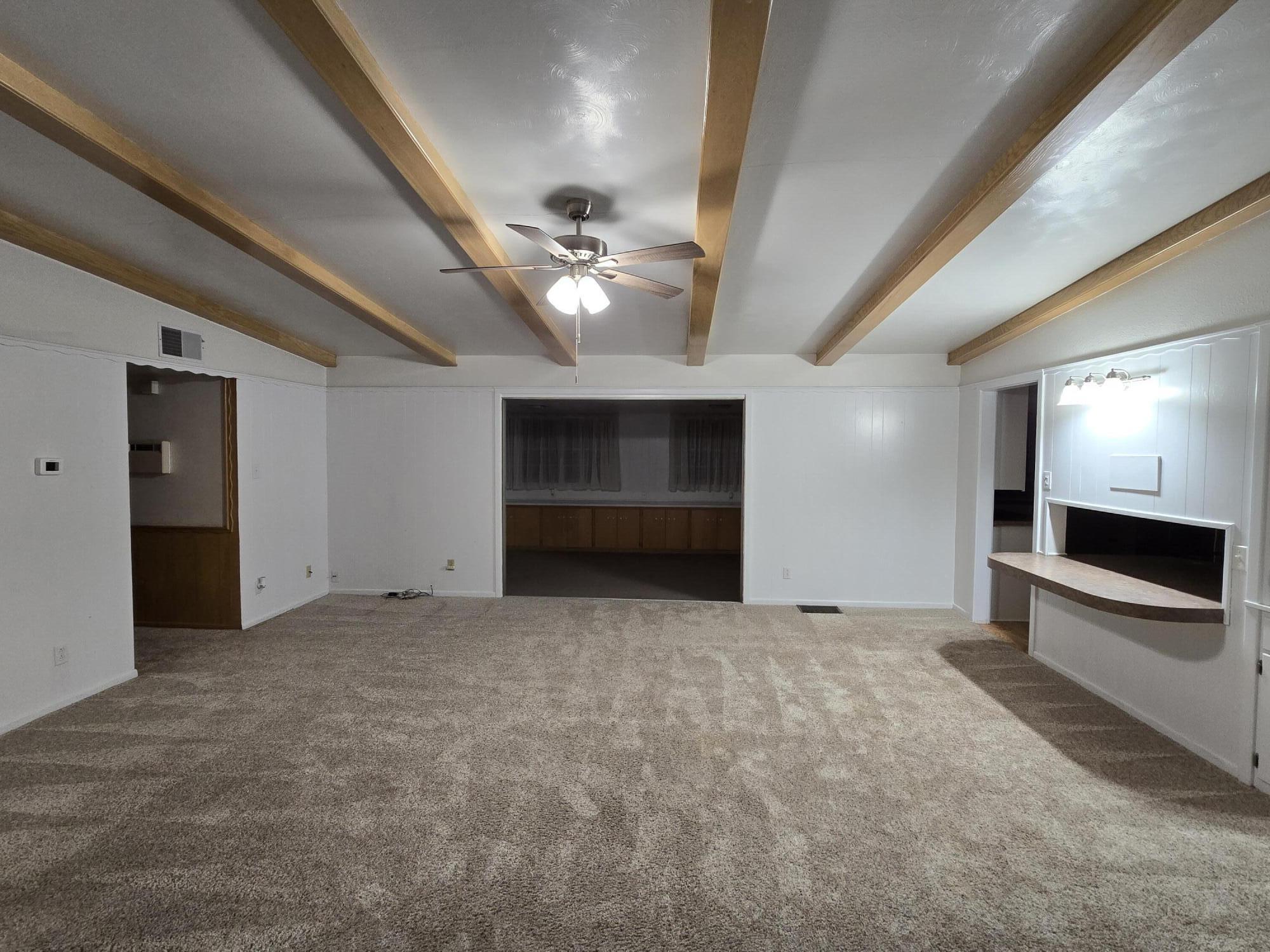 2229 South 6th Street Lamesa, TX 79331 - Photo 2 of 27 a view of an empty room with a fireplace and a ceiling fan