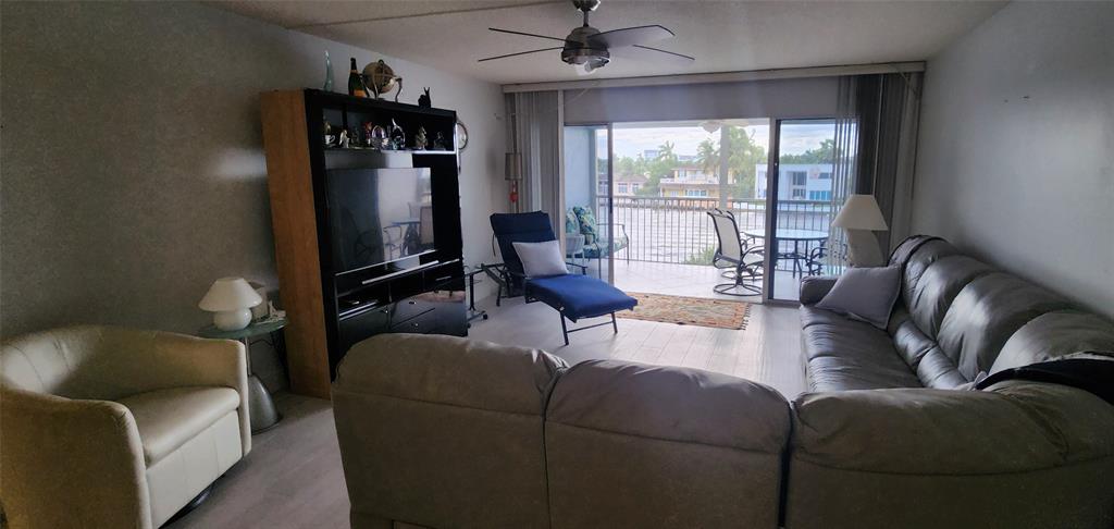 299 North Riverside Drive, Unit 303 Pompano Beach, FL 33062 - Photo 12 of 40 a living room with furniture and a flat screen tv