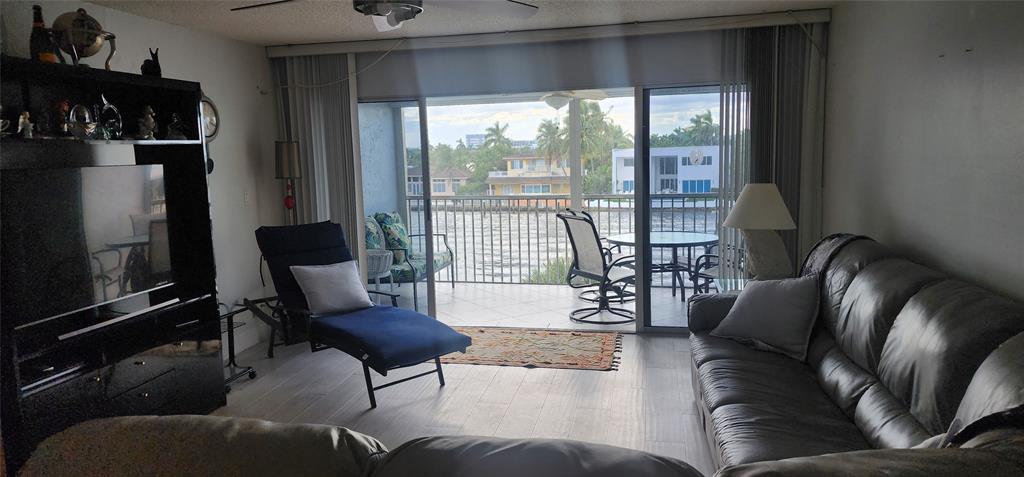 299 North Riverside Drive, Unit 303 Pompano Beach, FL 33062 - Photo 13 of 40 a living room with furniture and a floor to ceiling window