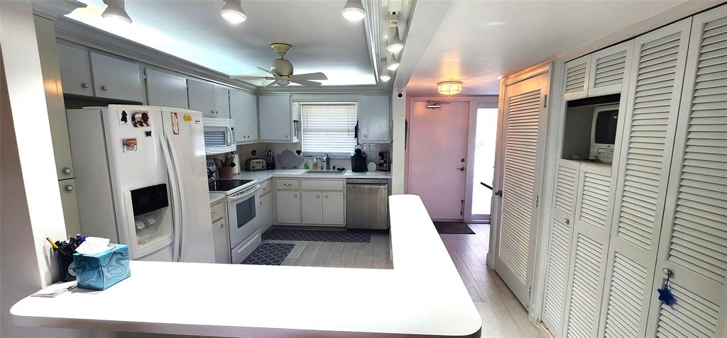 299 North Riverside Drive, Unit 303 Pompano Beach, FL 33062 - Photo 5 of 40 a kitchen with stainless steel appliances a refrigerator a sink a oven and white cabinets
