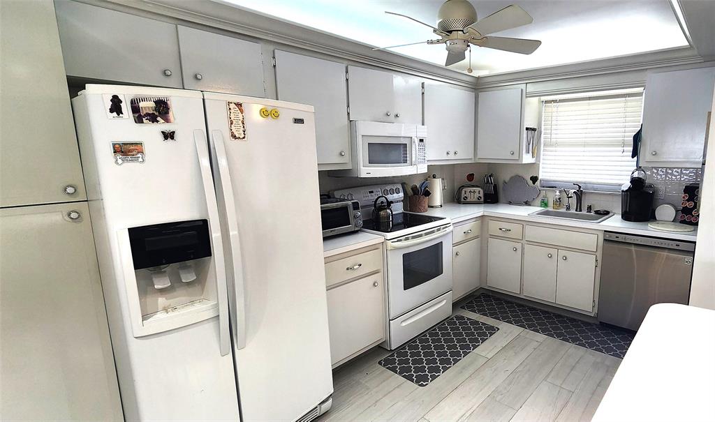 299 North Riverside Drive, Unit 303 Pompano Beach, FL 33062 - Photo 6 of 40 a white refrigerator freezer sitting inside of a kitchen